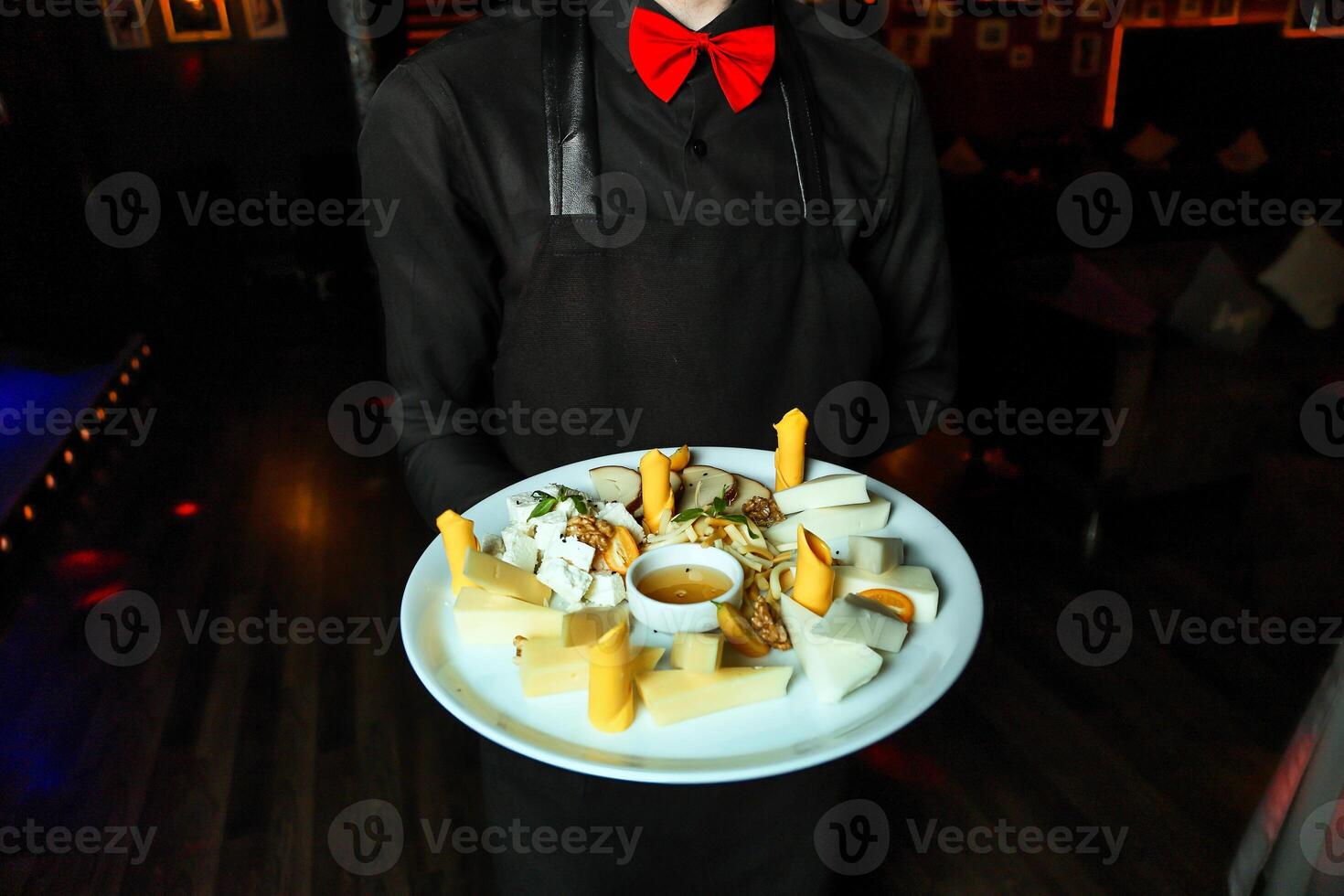 Man in Red Bow Tie Holding Plate of Food photo