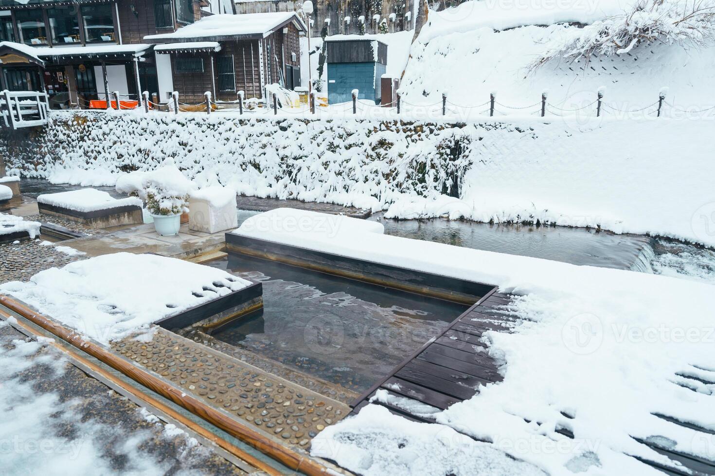 Foot bath hot spring in Ginzan Onsen with snow fall in winter season is most famous Japanese Hot Spring in Yamagata, Japan. photo