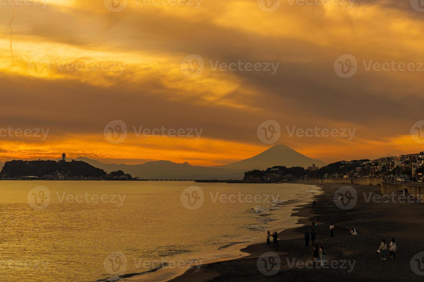 Scenery Kamakura Yuigahama Beach with Kamakura city and Fujisan mountain. Twilight silhouette Mount Fuji behind Enoshima island at Kamakura, Kanagawa, Japan. Landmark for tourist attraction near tokyo photo