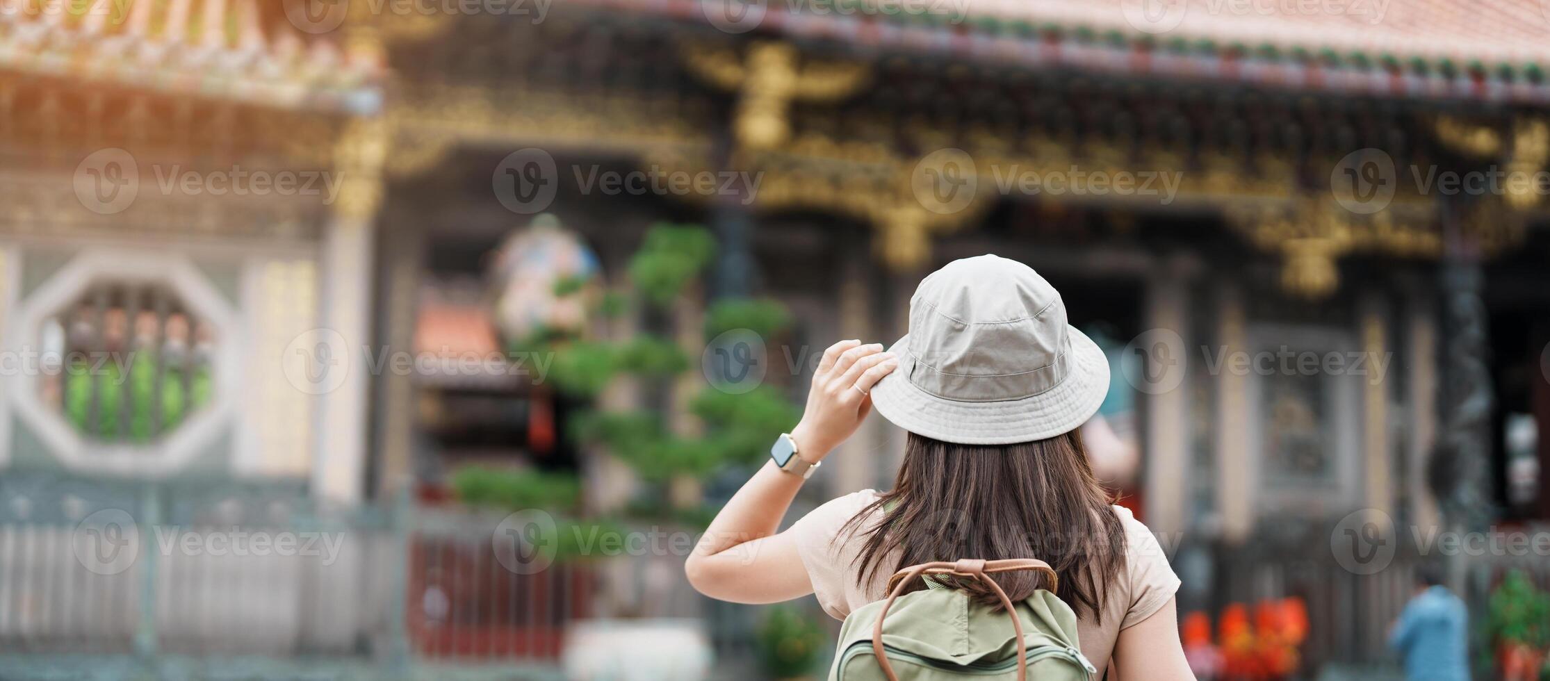 woman traveler visiting in Taiwan, Tourist with hat sightseeing in Longshan Temple, Chinese folk religious temple in Wanhua District, Taipei City. landmark and popular. Travel and Vacation concept photo