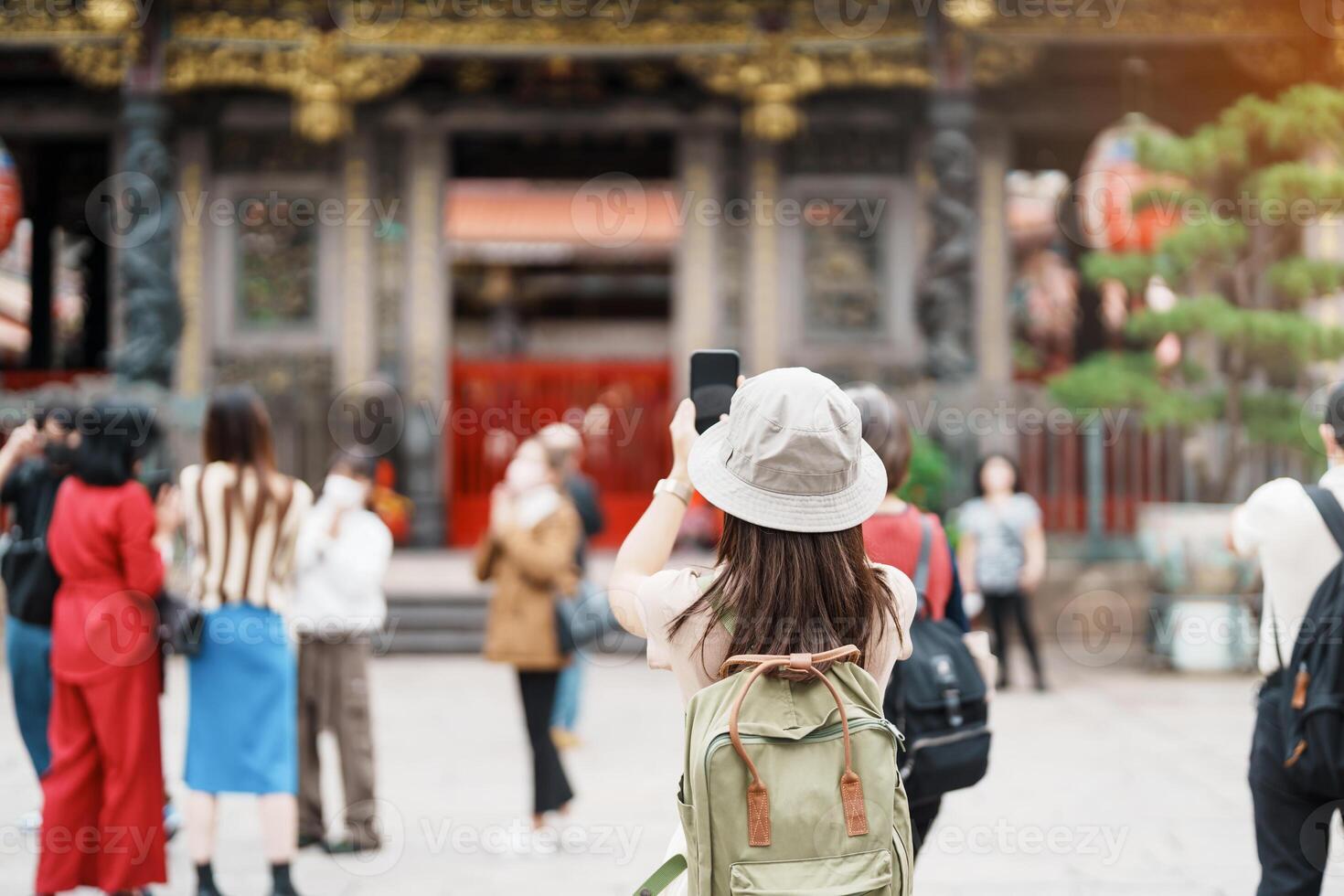 woman traveler visiting in Taiwan, Tourist with hat sightseeing in Longshan Temple, Chinese folk religious temple in Wanhua District, Taipei City. landmark and popular. Travel and Vacation concept photo