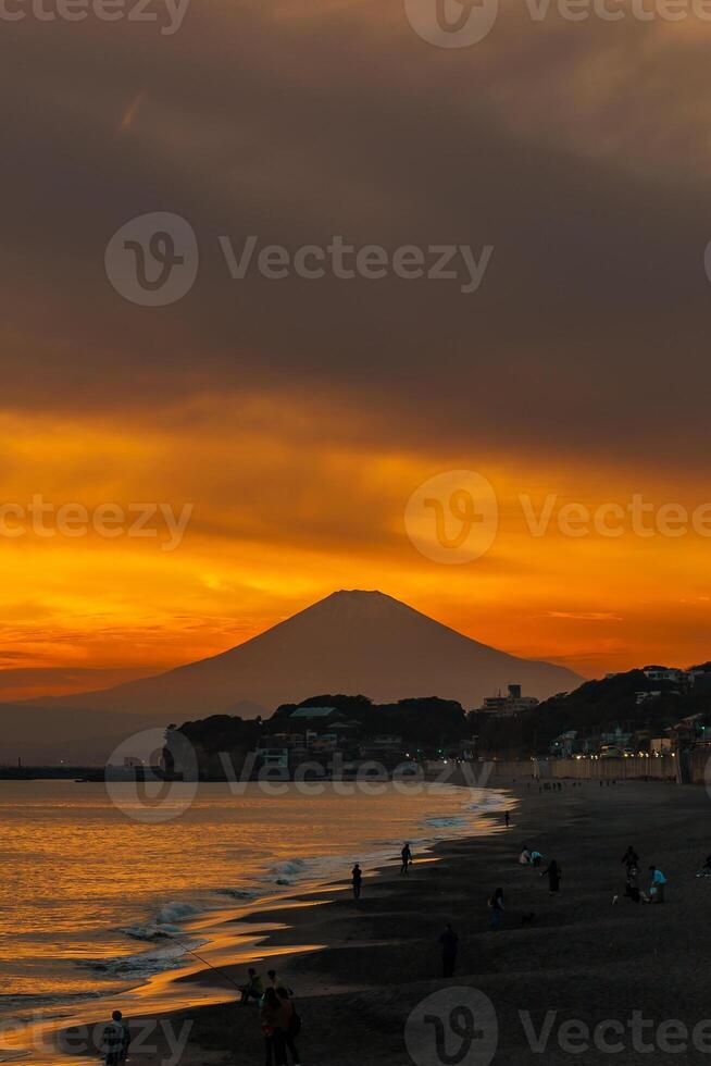 paisaje kamakura yuigahama playa con kamakura ciudad y fujisan montaña. crepúsculo silueta montar fuji detrás enoshima isla a kamakura, kanagawa, Japón. punto de referencia para turista atracción cerca tokio foto