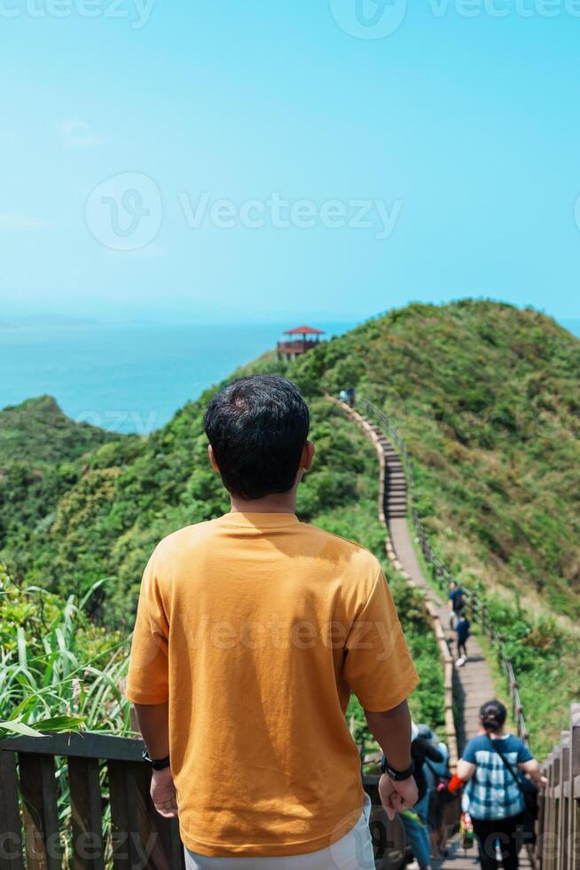 man traveler visiting in Taiwan, Tourist sightseeing in Bitou Cape Hiking Trail, New Taipei City. landmark and popular attractions near Taipei. Asia Travel concept photo