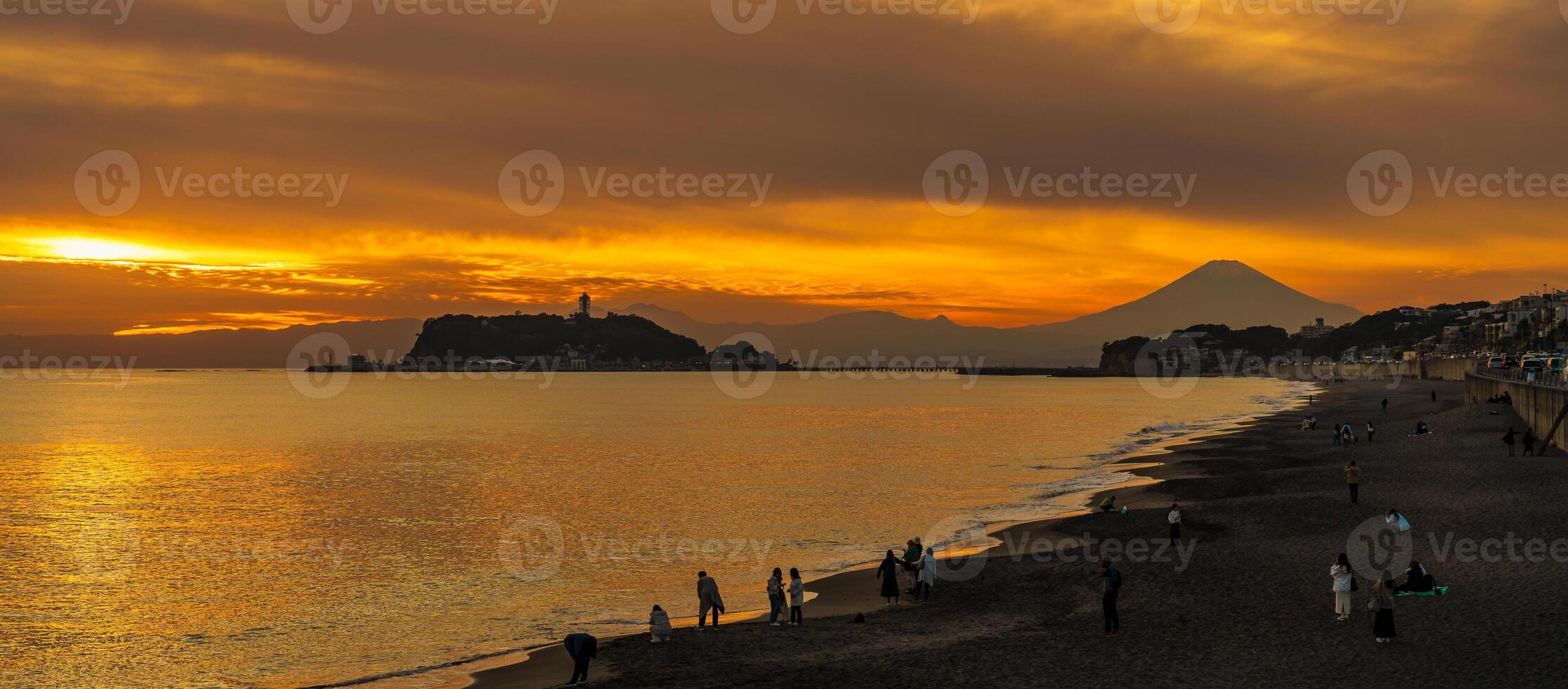 Scenery Kamakura Yuigahama Beach with Kamakura city and Fujisan mountain. Twilight silhouette Mount Fuji behind Enoshima island at Kamakura, Kanagawa, Japan. Landmark for tourist attraction near tokyo photo