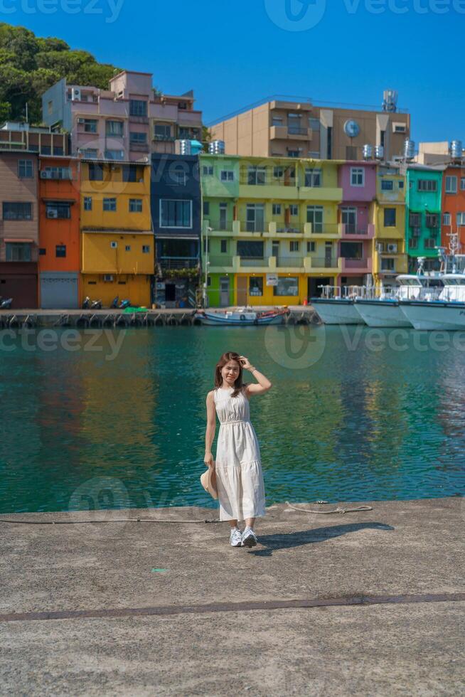 woman traveler visiting in Taiwan, Tourist with hat sightseeing in Keelung, Colorful Zhengbin Fishing Port, landmark and popular attractions near Taipei city . Asia Travel concept photo