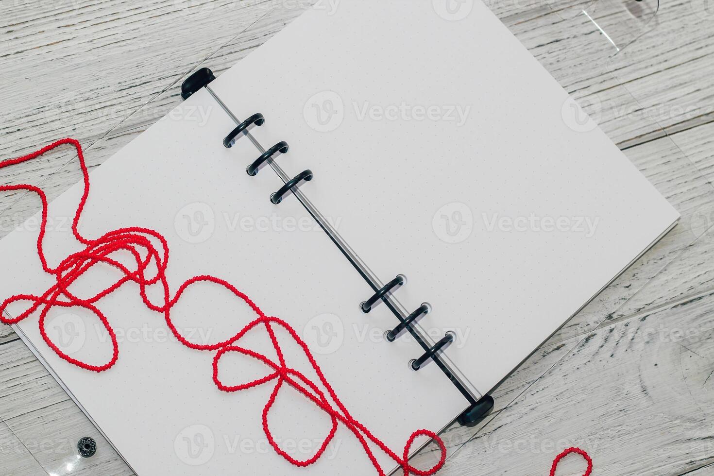Notebook with rings, checkered sheets, transparent cover, beads, style concept. photo