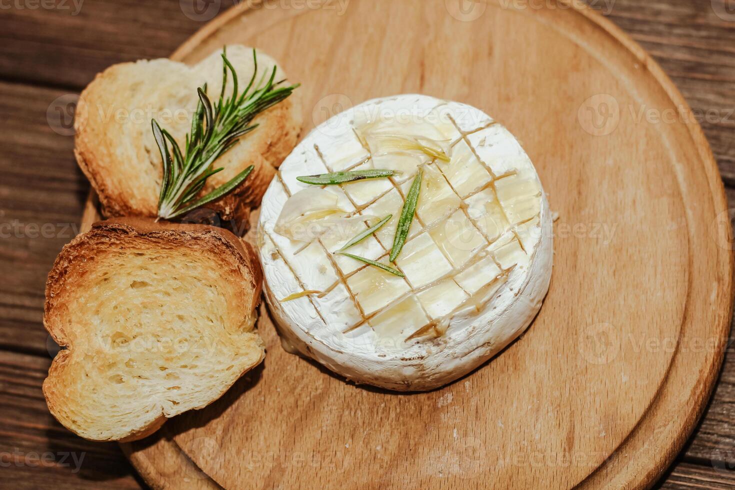White baguette cut into pieces with olive oil and Camembert cheese on the table. photo