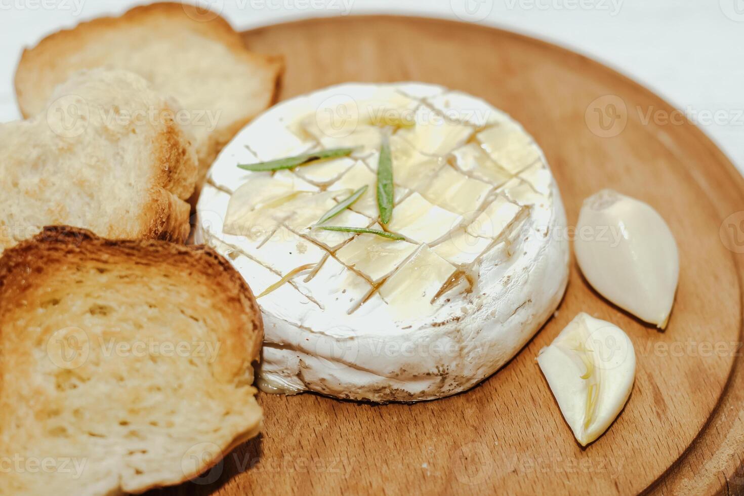 White baguette cut into pieces with olive oil and Camembert cheese on the table. photo