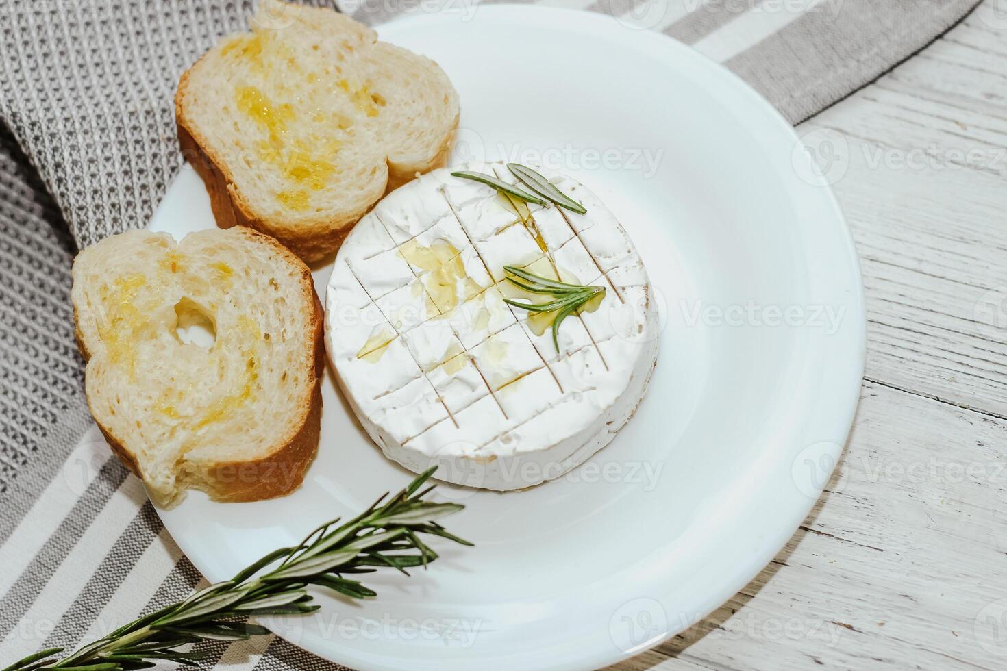 White baguette cut into pieces with olive oil and Camembert cheese on the table. photo