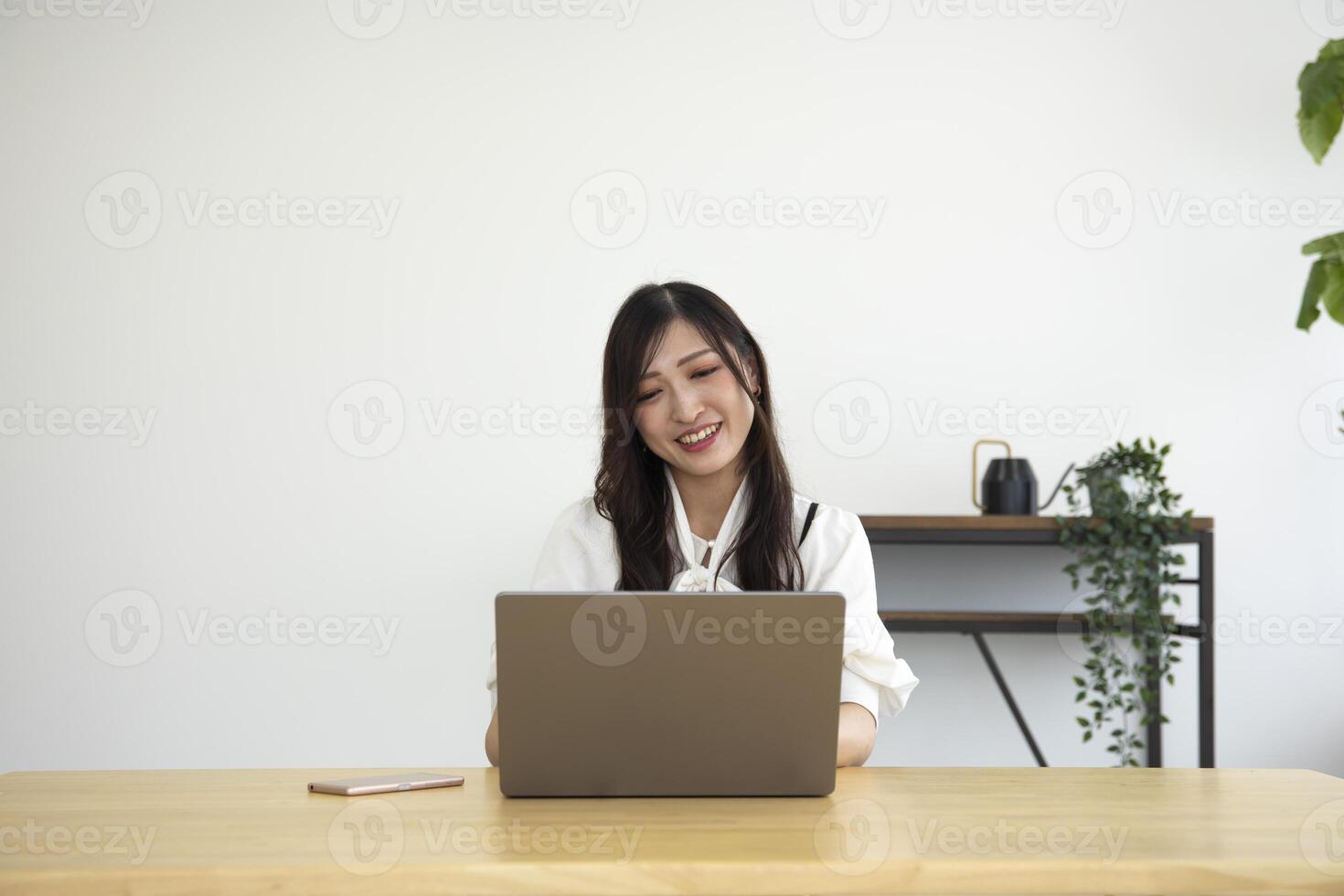 A Japanese woman checking smartphone by remote work in the home office photo