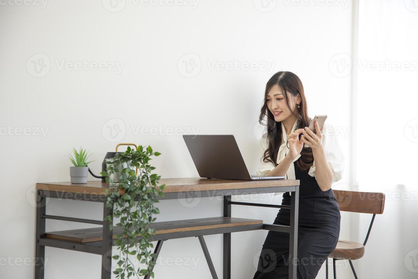 A Japanese woman checking smartphone by remote work in the home office photo