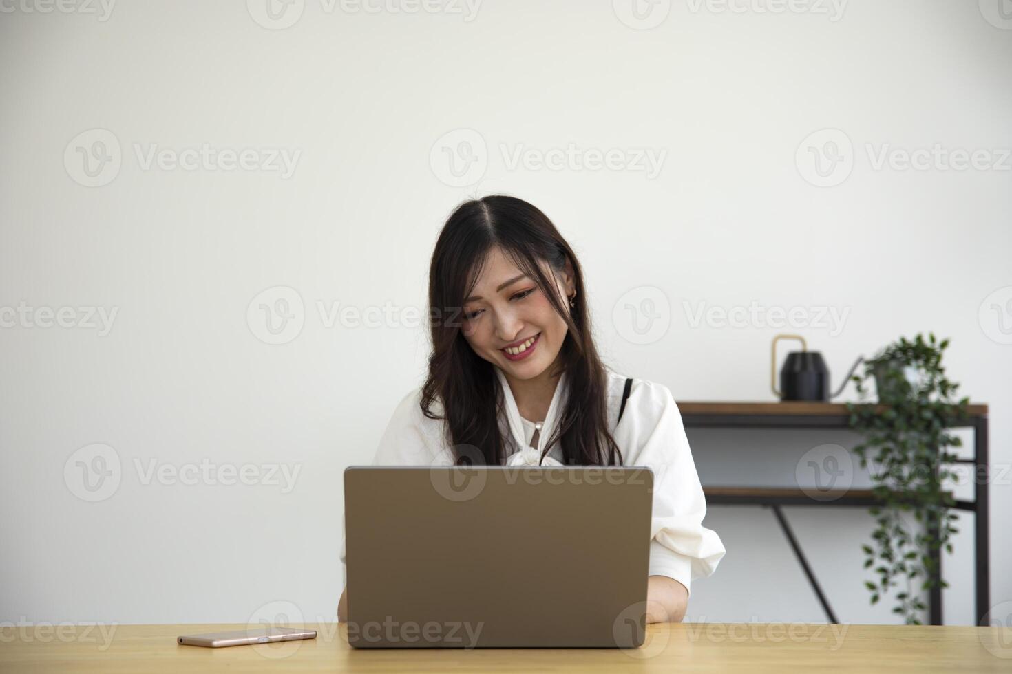 un trabajando japonés mujer por remoto trabajo en el hogar oficina de cerca foto