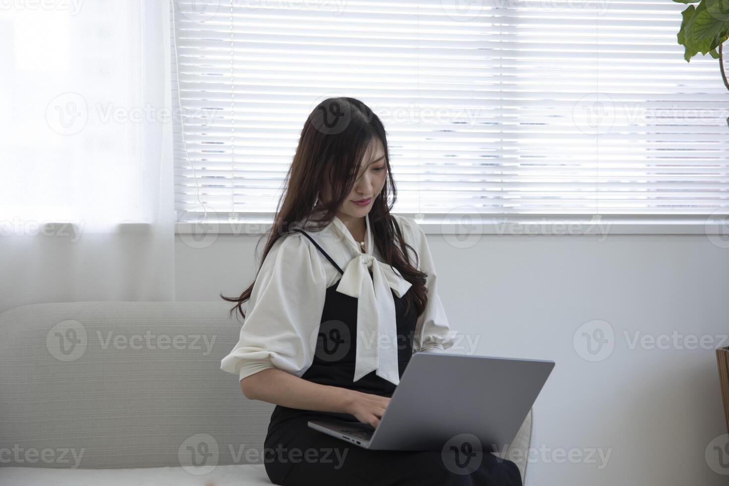A working Japanese woman by remote work in the home office closeup photo