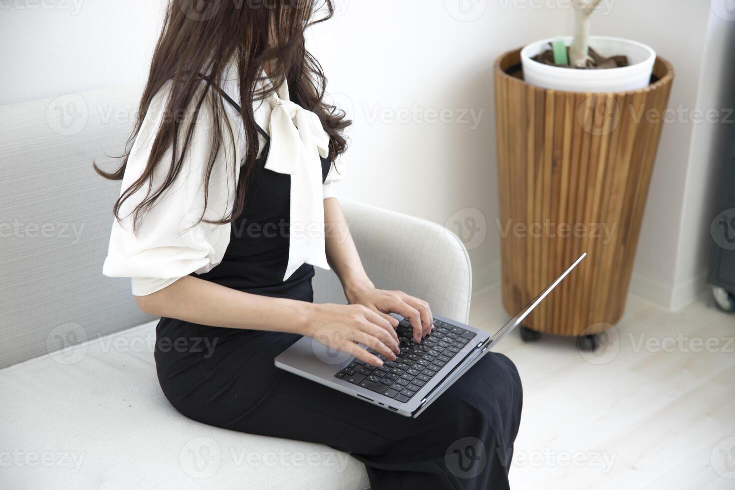 un japonés mujer mecanografía ordenador portátil por remoto trabajo en el oficina sin rostro composición foto