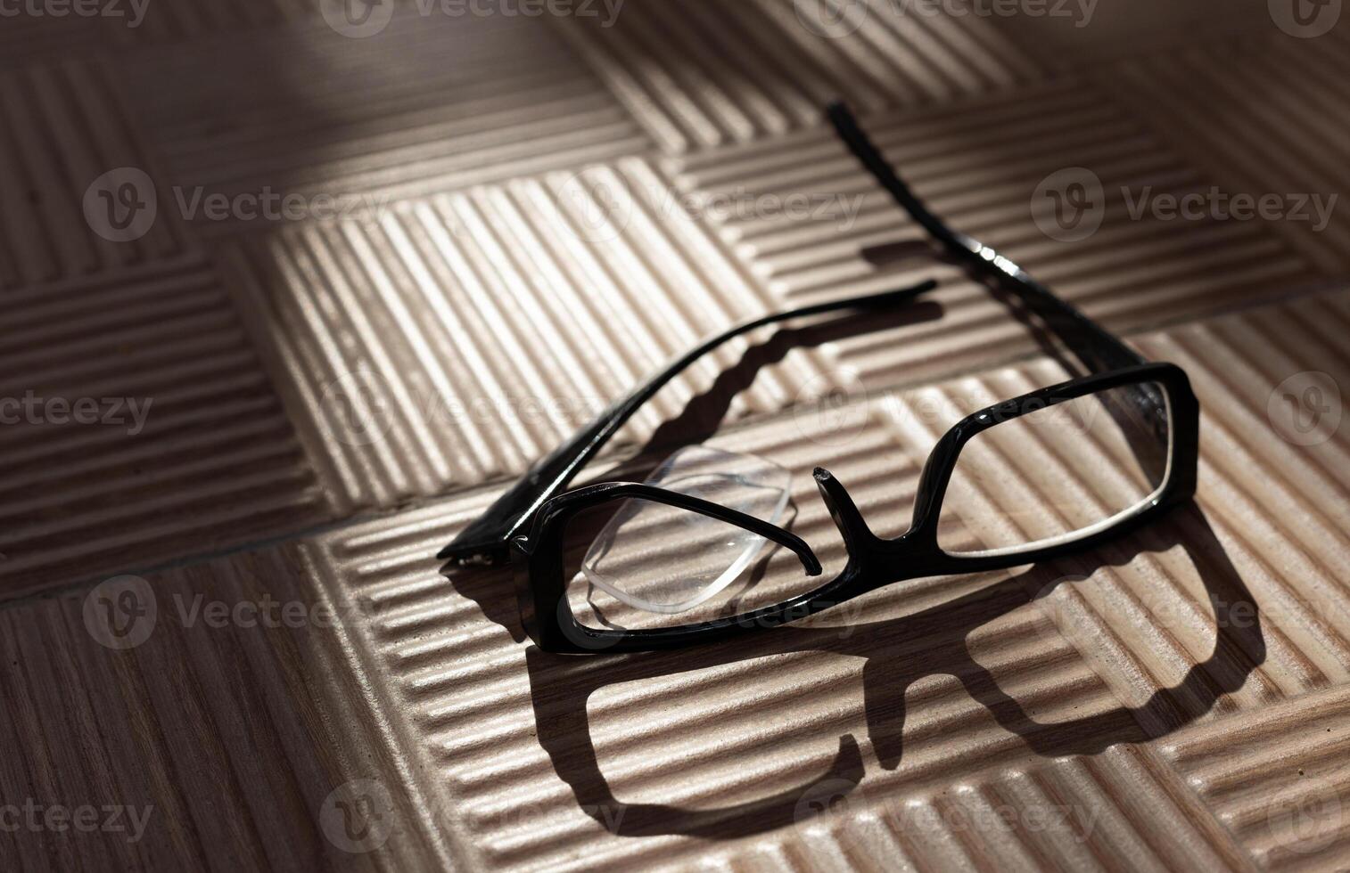 a broken eyeglass frame lies on a street ribbed tile in a beautiful shade from trees on a sunny day. High quality photo