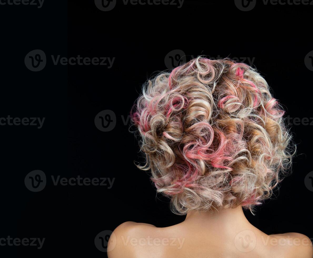 female hairstyle with wavy multi colored hair back view on black background. photo