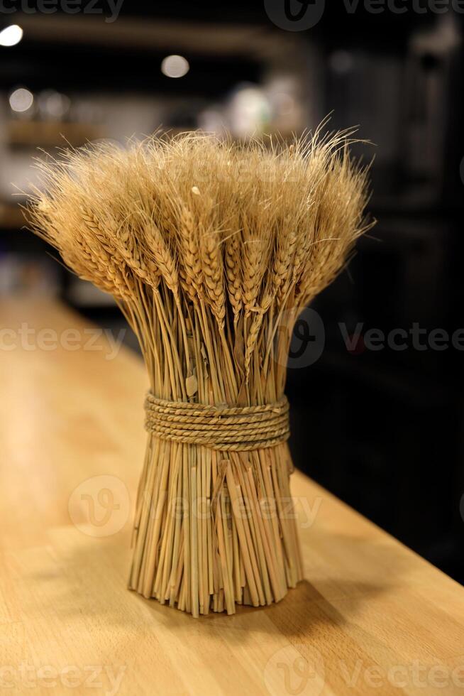 a beautiful stack of ripe ears of wheat stands on a wooden table. selective focus.High quality photo