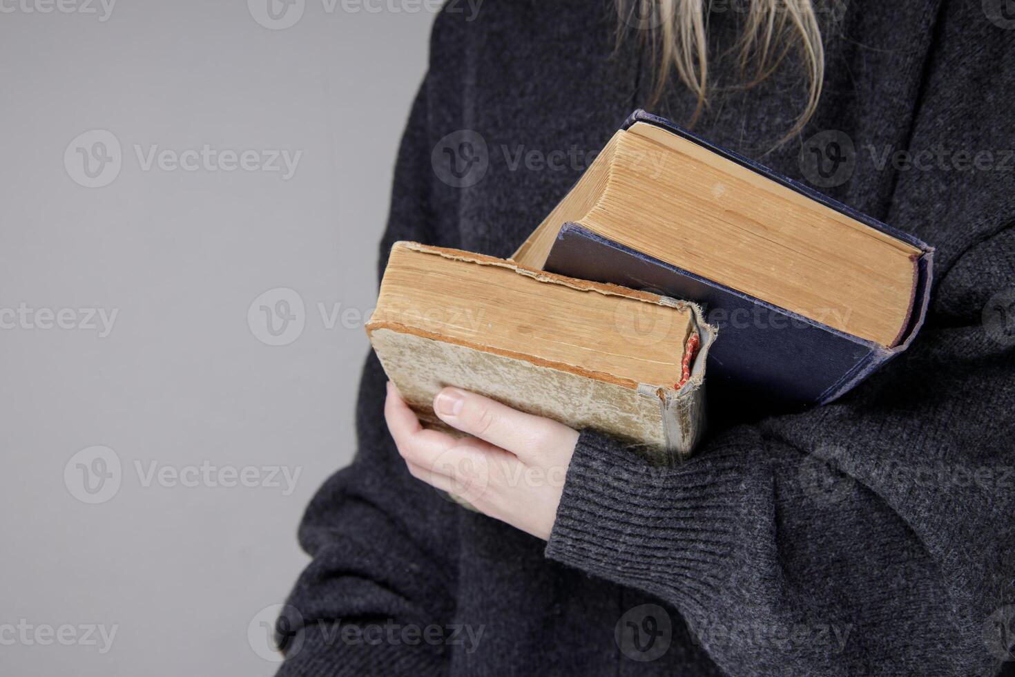 hands hold old books with brown textured paper and torn cover. vintage paper texture. selective focus photo