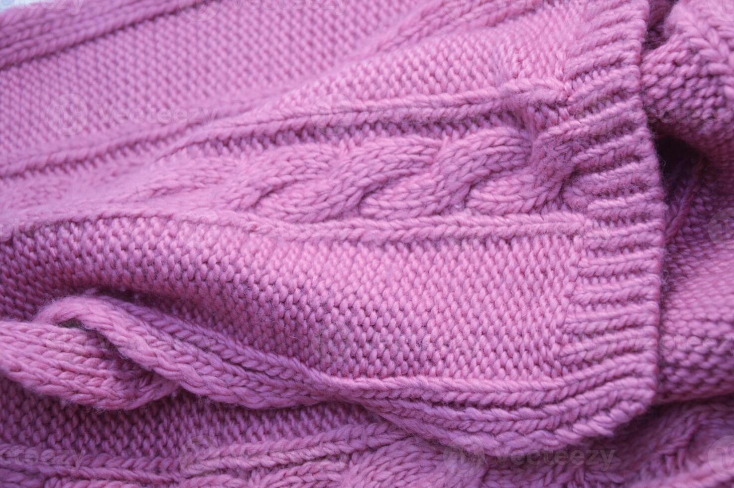 Pink lilac knitted wool sweater, scarf. Beautiful canvas with a textured pattern with braids. Background. photo