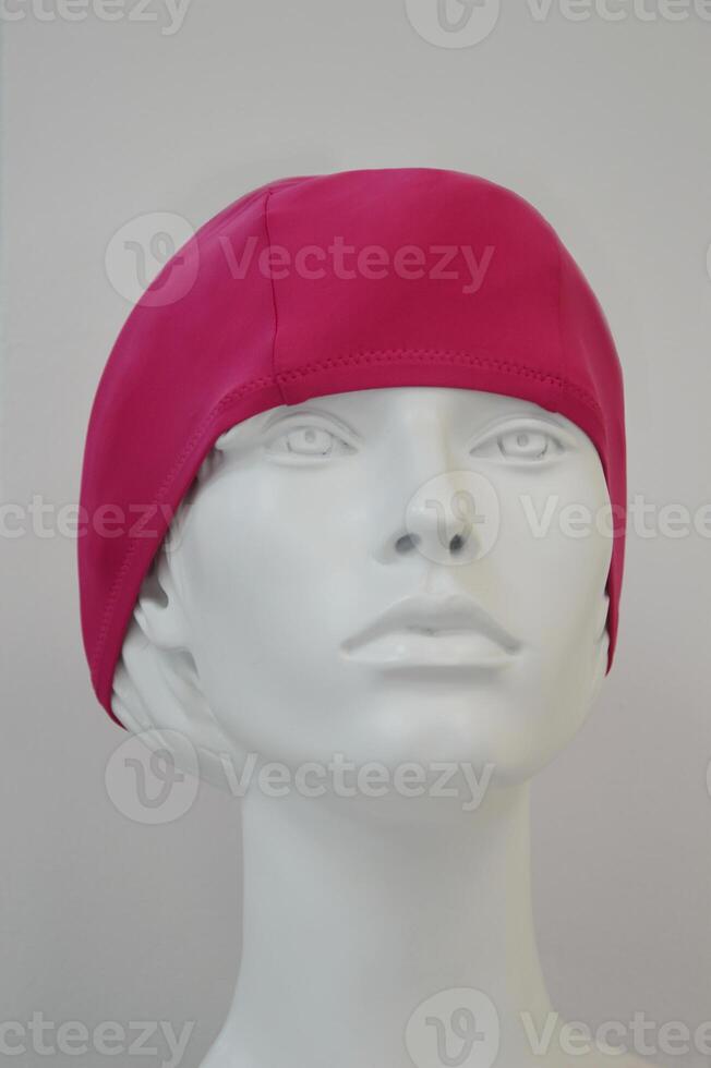 gorra para nadando en el piscina y en el playa. un rosado baños gorra para mujer en un maniquí en el comercio piso de el almacenar. foto