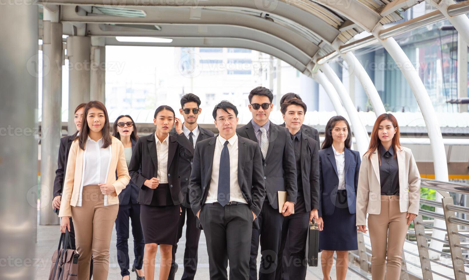 Group of happy young Asian business team, businesspeople walking the outdoor office together success teamwork for concepts photo