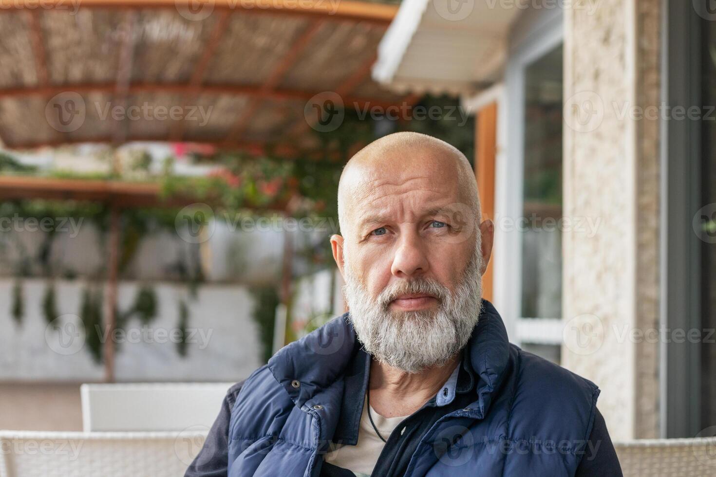 close-up portrait of a handsome adult man with gray hair in a cafe on the street. High quality photo