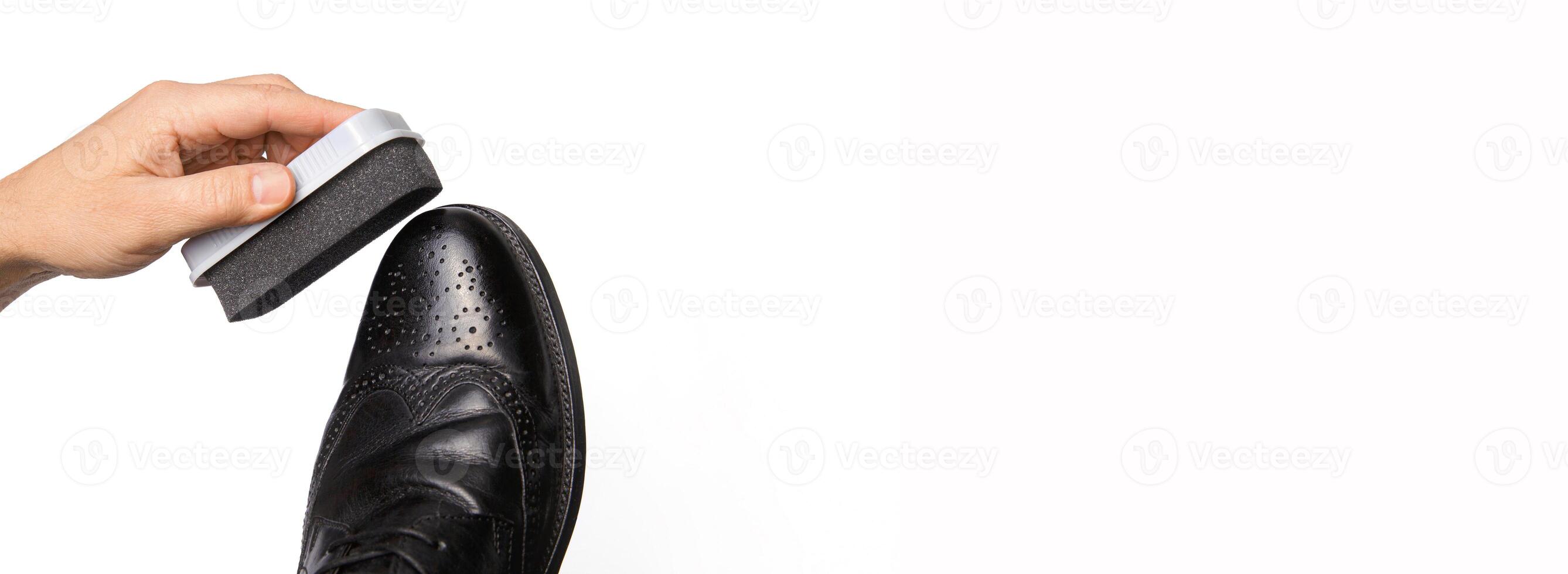Invisible man hand holds a shoe-cleaning sponge next to the shoe. banner .isolated on a white background.High quality photo