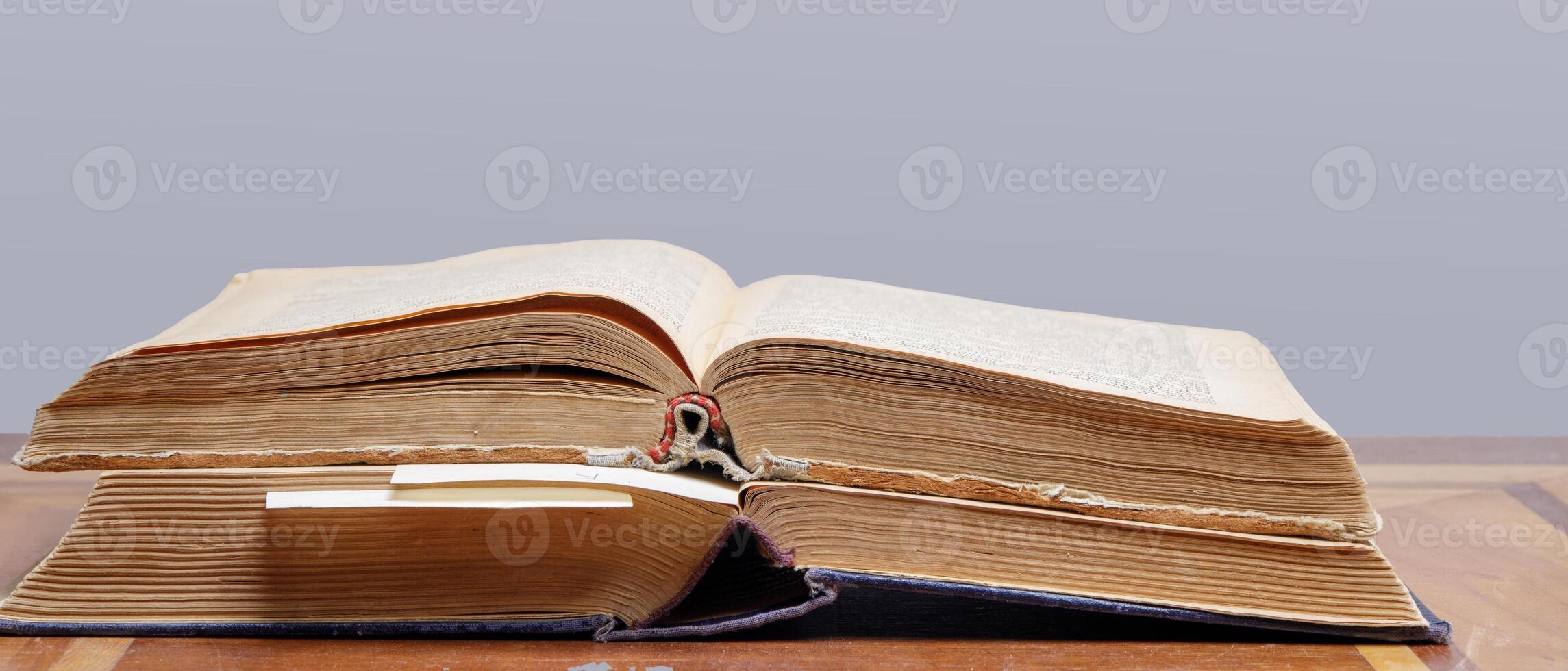 two old open books with bookmarks lie on a wooden table, close-up. High quality photo
