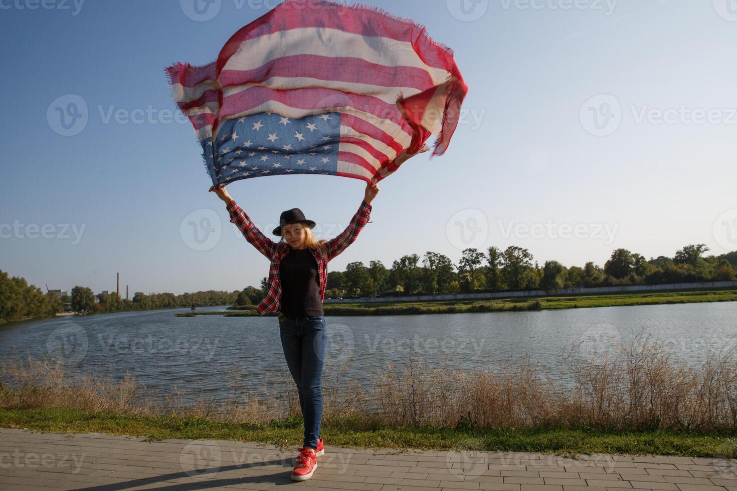 young girl with a scarf in the color of the American flag by the river.selective focus photo