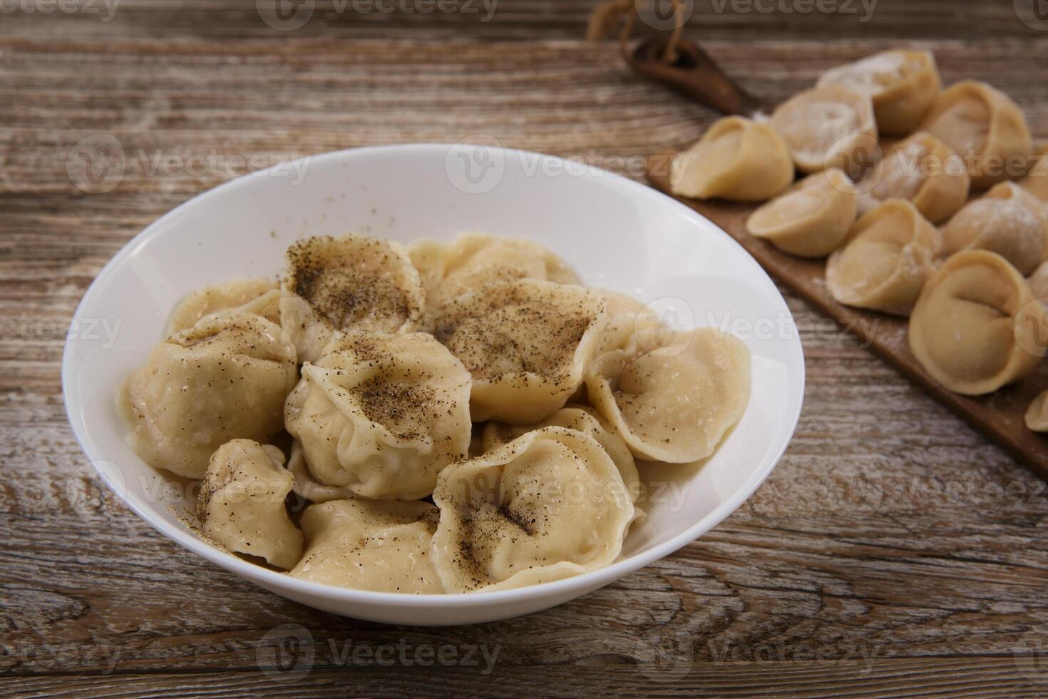 plate of homemade dumplings, and not boiled standing on the board. selective focus . photo