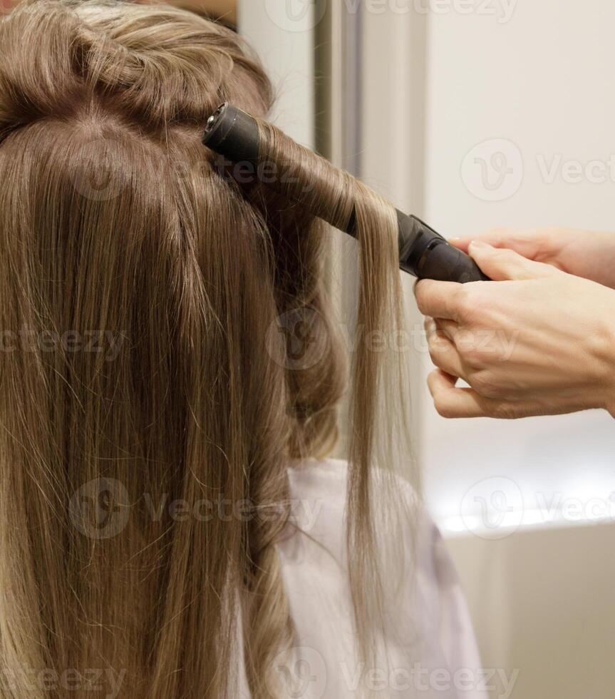 Invisible hairdresser's hands make a customer hair perm. selective focus.High quality photo