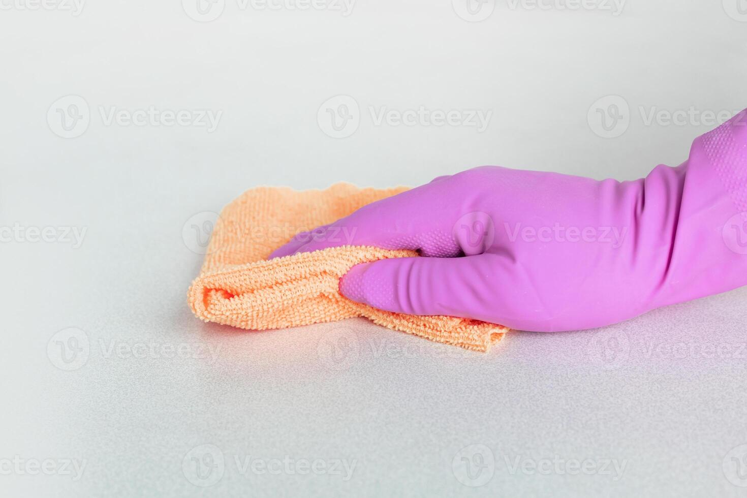 a hand in a pink glove wipes the surface with yellow microfiber. High quality photo