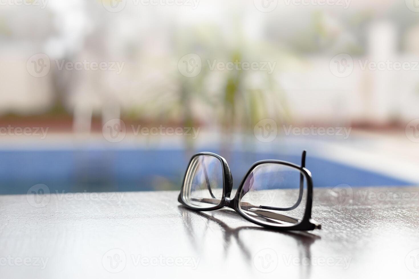 glasses lie on a dark wooden table. Black glasses with diopters on a wooden table. High quality photo