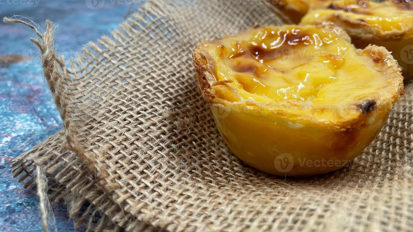 Lots of freshly baked desserts Pastel de nata or Portuguese egg tart. Pastel de Belm is a small pie with a crispy puff pastry crust and a custard cream filling. A small dessert, a cupcake. photo