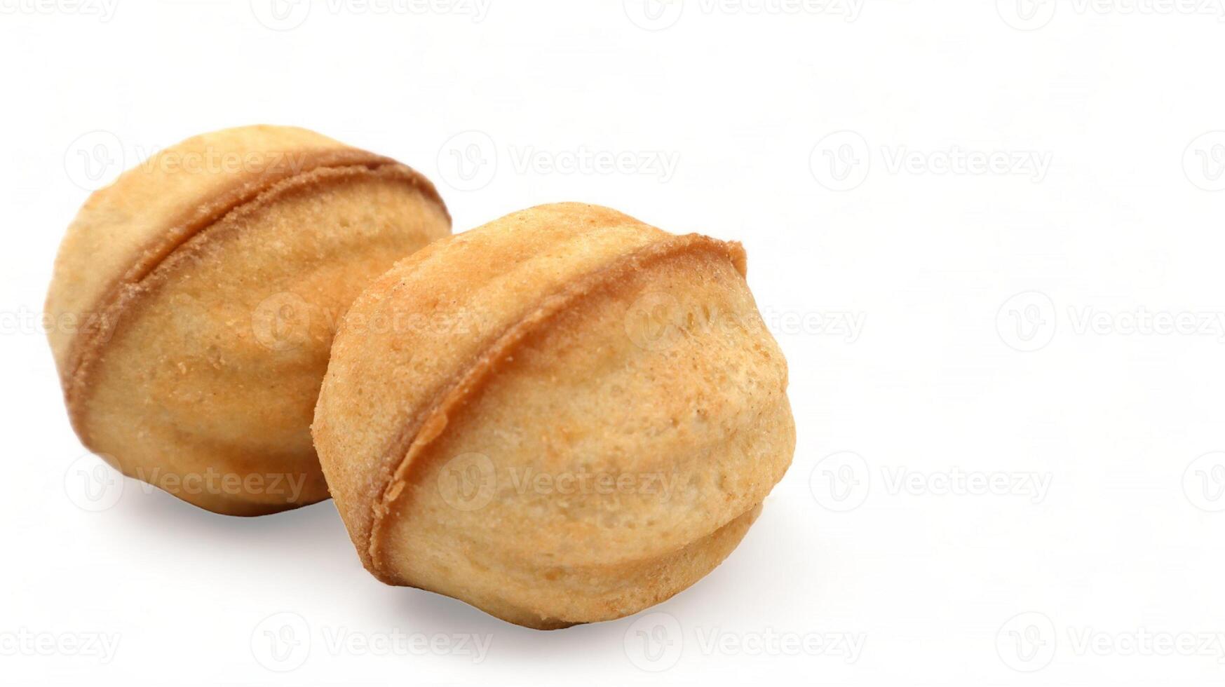 Two fresh and tasty cookies in the shape of a walnut with boiled condensed milk on a white background. A favorite delicacy for children and adults with a delicate filling inside. photo