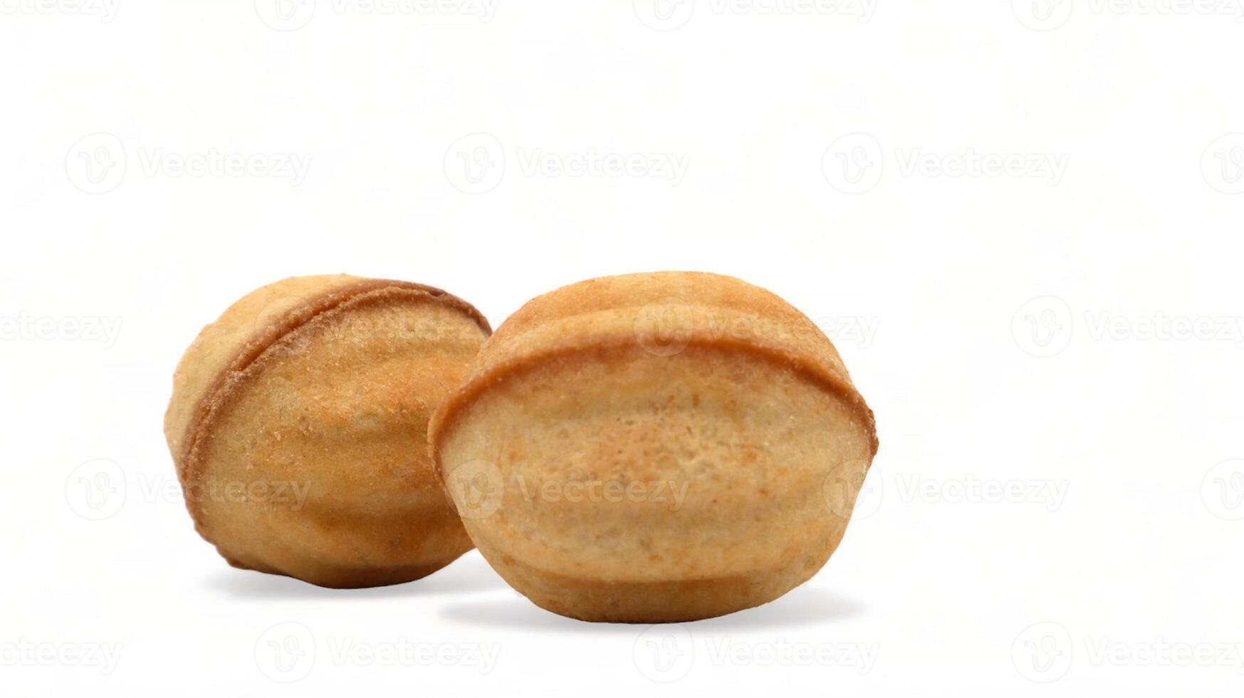 Two fresh and tasty cookies in the shape of a walnut with boiled condensed milk on a white background. A favorite delicacy for children and adults with a delicate filling inside. photo