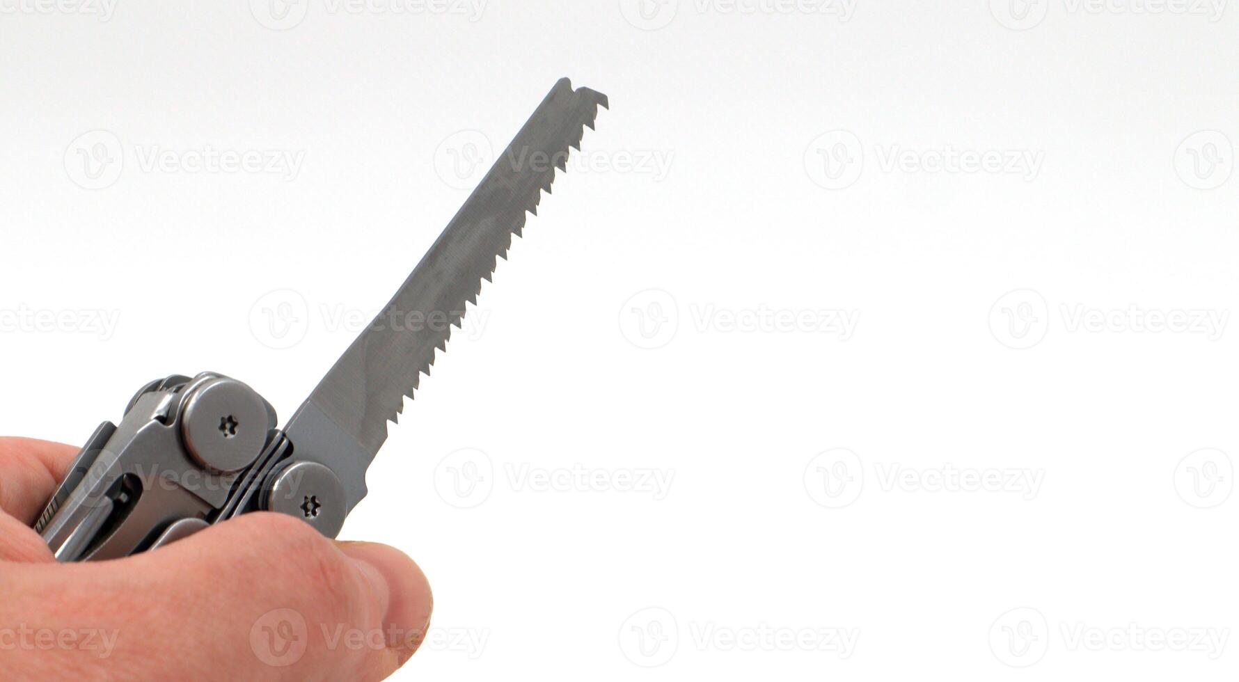 On a white background, a man's hand holds a steel multi-tool or pocket knife with an open saw. Compact and portable multi-tasking multitool with many tools. EDC concept. A tool for daily practice. photo