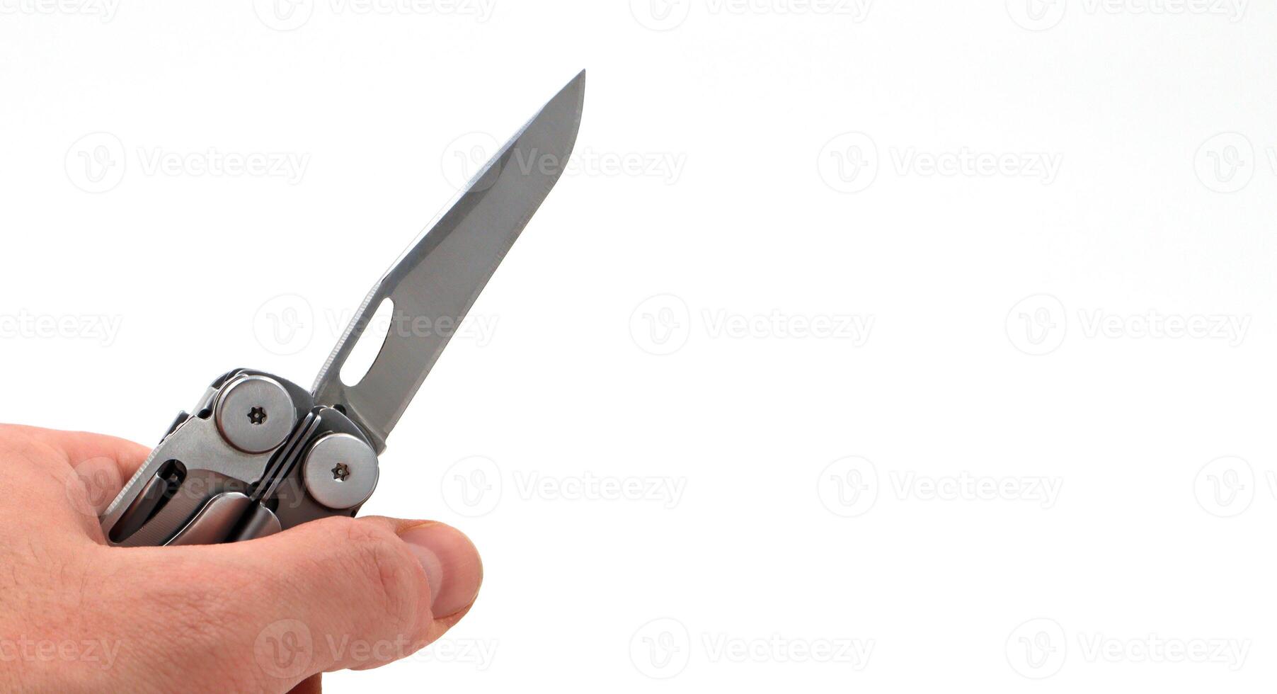 On a white background, a man's hand holds a steel multi-tool with an open knife blade. Pocket folding knife. Portable multi-tasking multi-tool with many tools. EDC concept. Tool for daily practice. photo