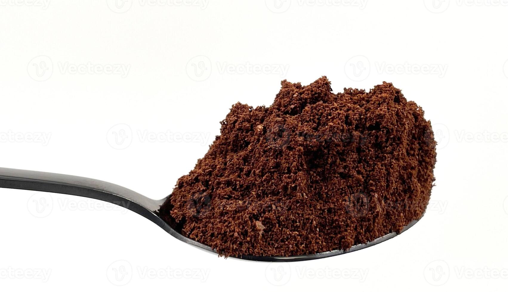 Ground coffee powder in a stainless steel teaspoon isolated on a white background. photo