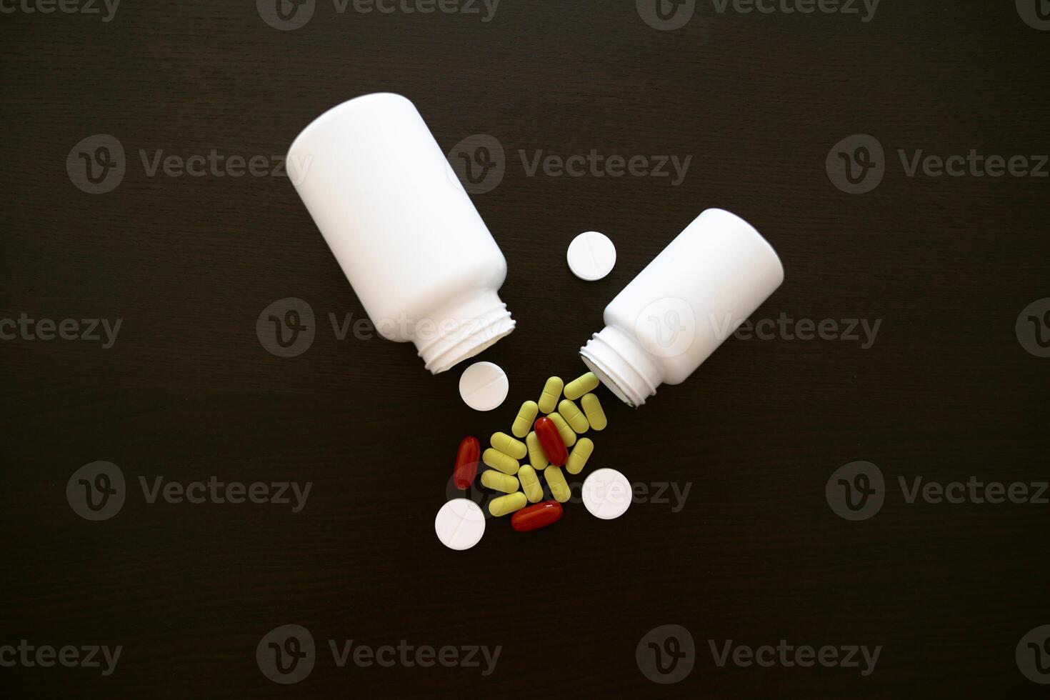 Scattered pills from a jar. Aspirin tablets. green, red and white tablets. photo