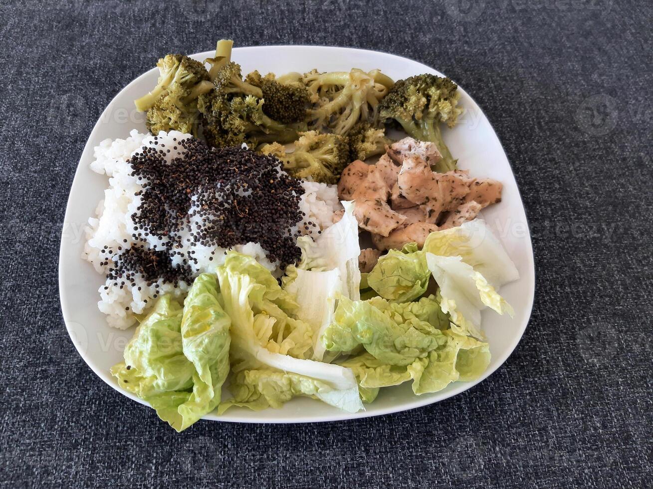 Homemade grilled chicken with rice and broccoli, served on a white plate photo