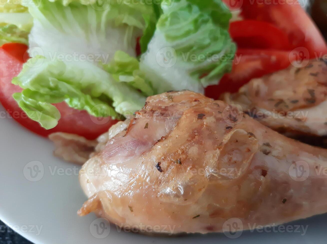 hecho en casa A la parrilla pollo piernas con A la parrilla espárragos, verde ensalada, rebanado tomatenand Pepino encurtido. foto