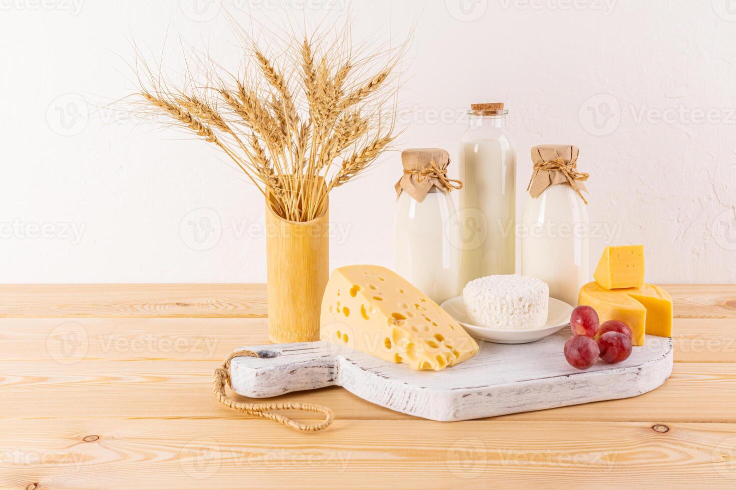 Fresco lechería productos en un blanco de madera tablero y un florero con orejas de maíz en un de madera mesa. concepto de el judío fiesta de shavuot. eco estilo foto