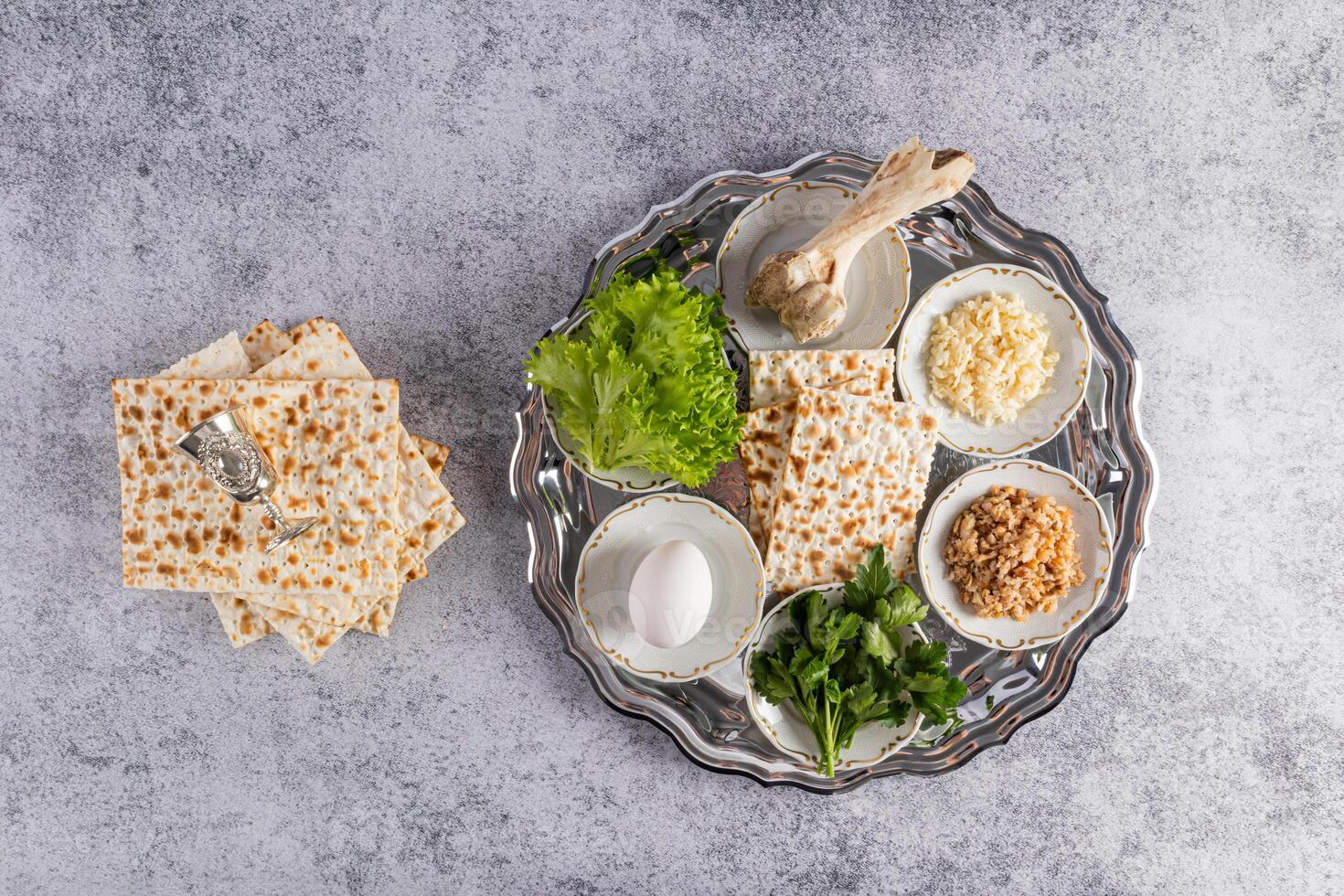 Top view of a silver rich seder tray with traditional treats for the Jewish Passover holiday. Marble background. Passover concept. photo