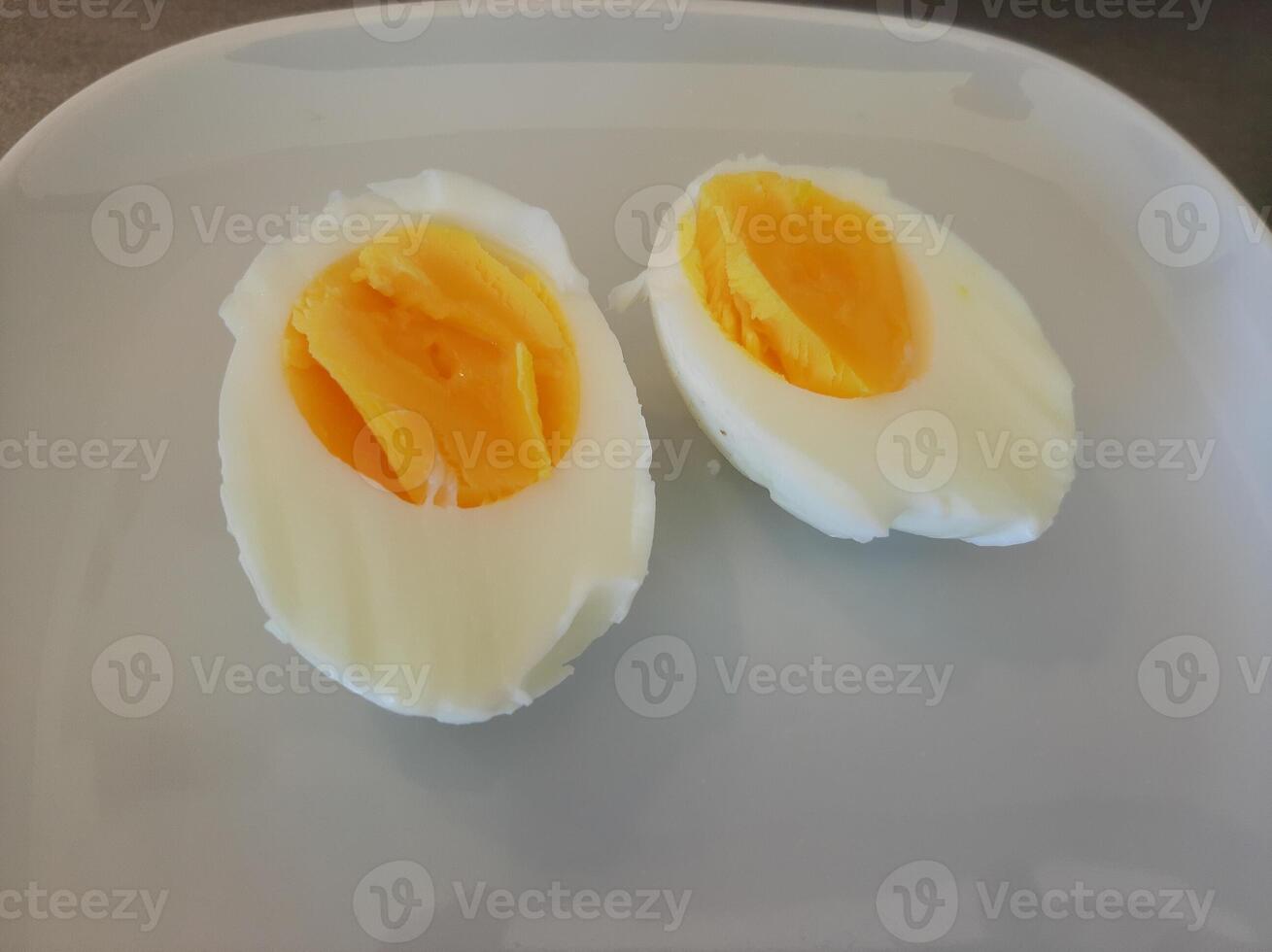un hervido rebanado huevo arreglado en un blanco plato foto