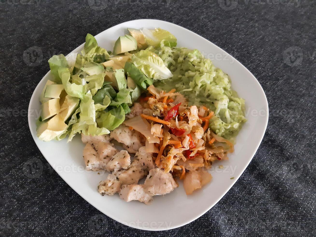 Homemade grilled chicken cooked zucchini, green salad, sliced avocado and Kimchi photo