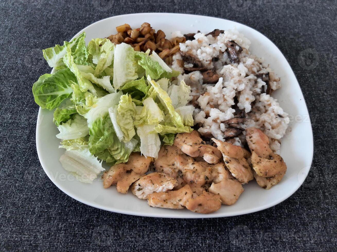 Homemade grilled chicken with grilled chopped eggplant, green salad, and rice Pilaf with mushrooms photo