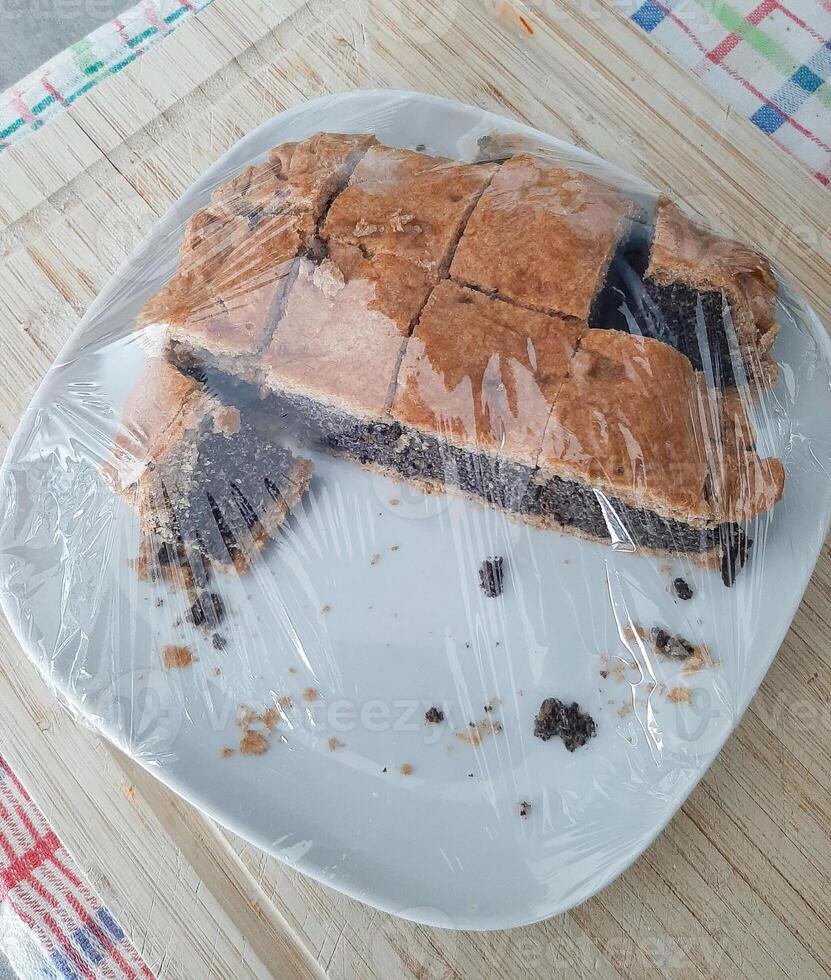 dulce hecho en casa tarta con amapola semillas arreglado en el plato en un de madera mesa foto