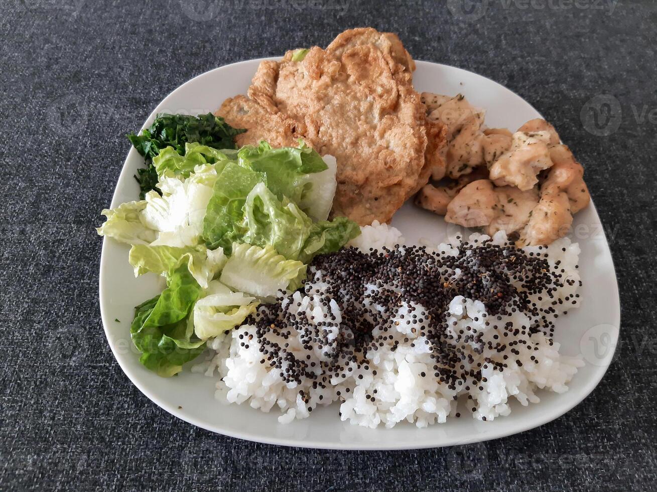 Homemade grilled chicken with grilled zucchini, green salad, spring rolls, rice pilaf and parsley. Broccoli seeds on top of the rice pilaf. photo