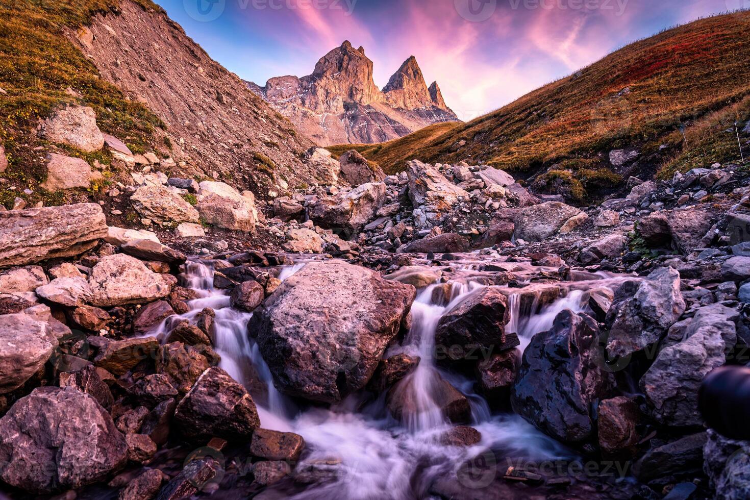 Aiguilles d'Arves with iconic mountain and waterfall flowing in French Alps photo